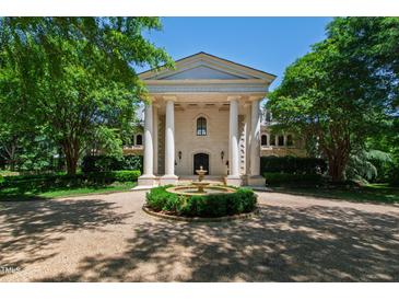 Front view of a sophisticated home featuring a circular drive and manicured landscaping at 6510 New Market Way, Raleigh, NC 27615