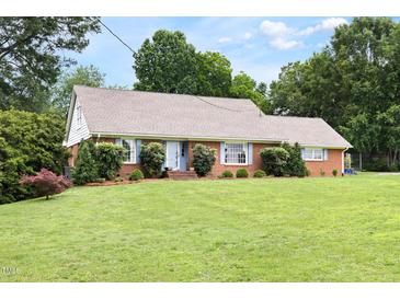 Charming brick ranch home featuring a well-manicured lawn and landscaping at 816 Miller Rd, Hillsborough, NC 27278