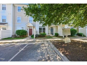 Townhouse exterior featuring neutral siding, well-kept landscaping, and visible community signage at 8621 Neuse Club Ln # 106, Raleigh, NC 27616