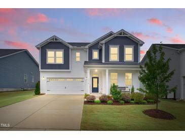 Charming two-story home featuring a well-manicured lawn, beautiful landscaping, and a classic facade at 1112 Prewitt Ranch Dr, Holly Springs, NC 27540