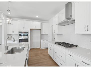 Bright kitchen with white cabinetry, stainless appliances, gas cooktop, and quartz countertops at 112 Moonflower Ln # Homesite 267, Wilson's Mills, NC 27520