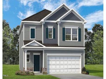 Charming two-story home with gray siding, white trim, and a two-car garage offers curb appeal at 128 Bruce Dr, Dunn, NC 28334
