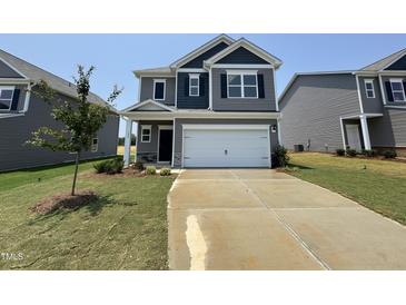 Two-story home with gray siding, a two-car garage, and a well-manicured front lawn at 128 Bruce Dr, Dunn, NC 28334