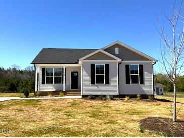 Charming single-story home featuring classic architectural details and a well-manicured front lawn at 140 Brookhaven Dr, Spring Hope, NC 27882
