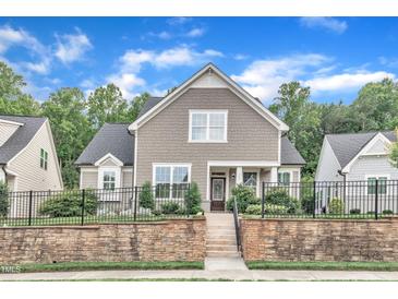 Inviting two-story home featuring a stone retaining wall and a well-maintained front yard at 151 Bridge St, Hillsborough, NC 27278