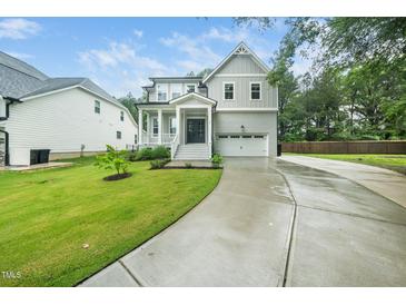 Charming two-story home with a gray exterior, landscaped yard, and attached two-car garage at 20 Scotland Dr, Youngsville, NC 27596