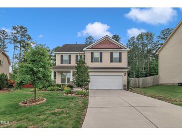 Charming two-story home featuring a two-car garage, well-manicured lawn, and lovely landscaping at 2018 Morehead Hill Ct, Durham, NC 27703