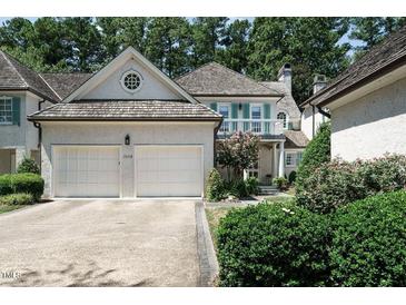 Charming home featuring a two-car garage, balcony, dormer windows, and manicured landscaping at 203 Edinburgh Dr # B, Cary, NC 27511