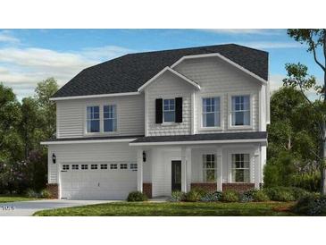 Charming two-story home featuring a two-car garage and a welcoming covered front porch at 204 Hickory Grove St, Sanford, NC 27330
