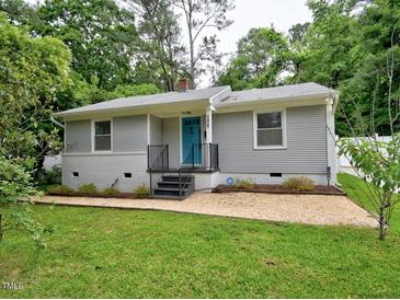 Charming single-story home with gray siding, blue door, updated landscaping, and welcoming curb appeal at 2409 Derby Dr, Raleigh, NC 27610