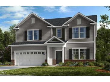 Charming two-story home boasts gray siding, attached garage and well-maintained landscaping at 515 Claftin St, Sanford, NC 27330