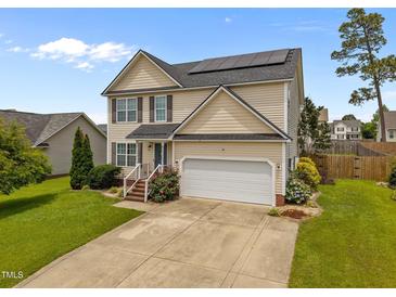 Charming two-story home with a two car garage, solar panels and a well-maintained front yard at 76 Haywood St, Spring Lake, NC 28390
