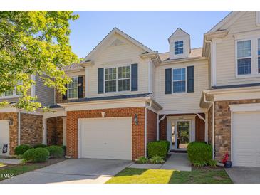 Charming two-story townhome with a brick-accented garage and manicured landscaping at 8404 Saltwood Pl, Raleigh, NC 27617