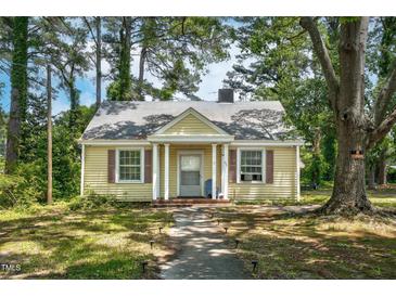 Charming yellow home with welcoming front porch and mature trees in a peaceful neighborhood at 940 Hill St, Rocky Mount, NC 27801