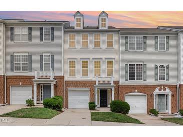 Charming townhouse exterior featuring a brick base, vinyl siding, and attached garages at 109 Ruby Walk Dr, Morrisville, NC 27560