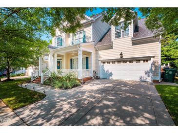 Charming two-story home featuring a welcoming front porch, well-maintained lawn, and attached two-car garage at 116 Hamilton Hedge Pl, Cary, NC 27519