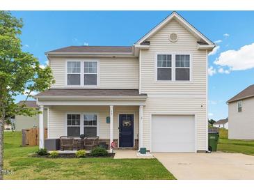 Charming two-story home featuring a welcoming front porch, attached garage, and well-maintained lawn at 13 Toplanders Ter, Gibsonville, NC 27249