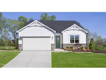 Charming single-Gathering home boasts white siding, stone accents, a green front door, and a well-manicured lawn at 158 Vaughan Farms Drive Dr, Angier, NC 27501
