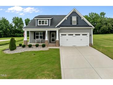 Charming home featuring a two-car garage, well-manicured lawn, and inviting front porch at 206 Heart Pine Dr, Wendell, NC 27591