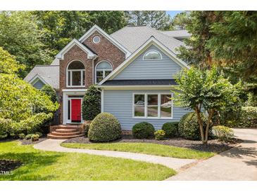 Charming two-story home with a red front door, brick accents, manicured landscaping, and a walkway leading to the entrance at 215 Collinson Dr, Chapel Hill, NC 27514