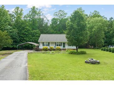 Charming single-story home with a well-maintained lawn, cozy porch, and convenient carport at 215 Virginia Pine Dr, Clayton, NC 27520