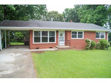 Charming brick home featuring a cozy front porch and a convenient covered carport, all set on a lush green lawn at 2626 Crestline Ave, Raleigh, NC 27603