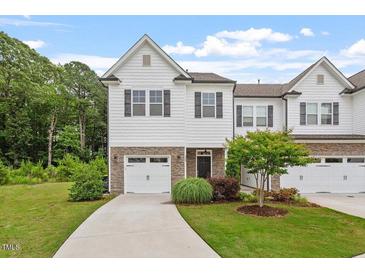 Charming two-story townhome featuring a stone accents, a single-car garage, and a well-manicured lawn at 520 Kenton Mill Ct, Rolesville, NC 27571