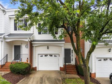 Charming townhouse with brick accents, featuring an attached garage and inviting front entrance at 5506 Cottonrose Ln, Raleigh, NC 27606