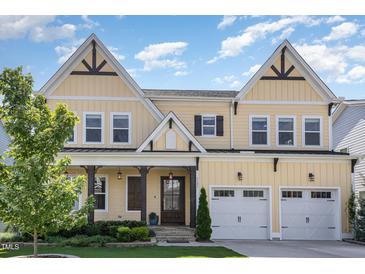 Inviting two-story home with a charming front porch and a well-manicured lawn, featuring a two-car garage at 1131 Lowland St, Apex, NC 27523