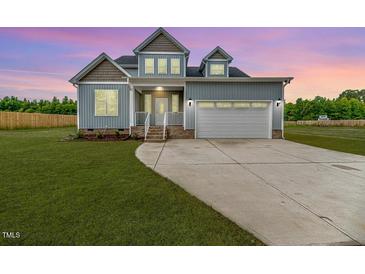 Charming two-story home featuring blue siding, a two-car garage, and a well-manicured lawn at 117 Knight Rd Rd, Broadway, NC 27505