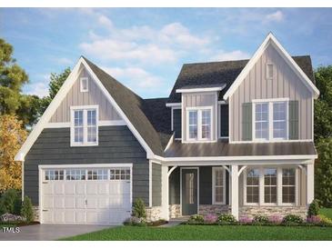 Charming two-story home featuring a two-car garage, inviting front porch, and beautiful architectural details at 153 E Victoria Ridge Dr # 11, Selma, NC 27576