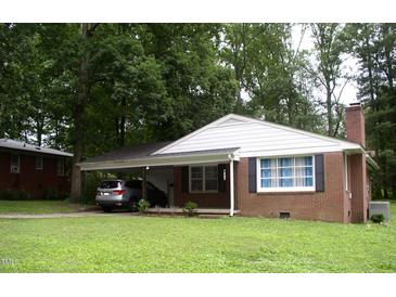 Charming brick home featuring a convenient carport, well-maintained lawn, and mature shade trees at 1809 S Garnett Ext, Henderson, NC 27536