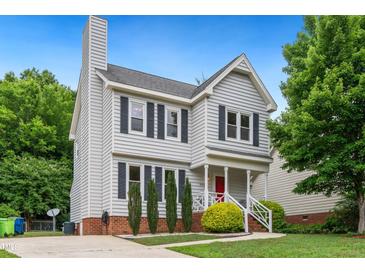 Charming two-story home with gray siding, black shutters, manicured landscaping, and a red front door at 3405 E Jameson Rd, Raleigh, NC 27604