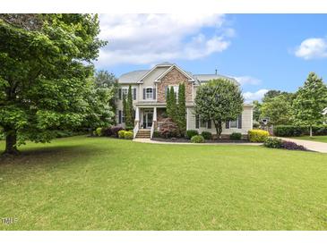 Charming two-story home with stone accents, mature trees, and a sprawling green lawn at 5516 Colonial Oaks Dr, Apex, NC 27539