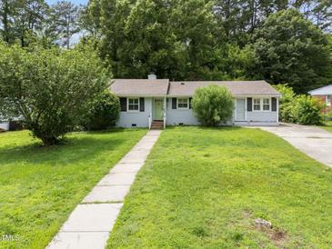 Charming single-story home with a well-manicured lawn, sidewalk, driveway, and lush landscaping at 808 Ravenwood Dr, Raleigh, NC 27606