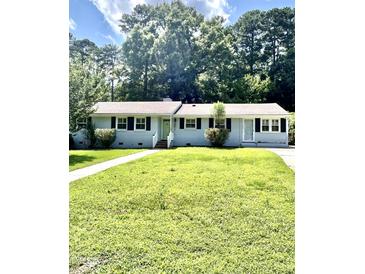 Charming one-story home with a beautiful lawn, walkway, and lovely curb appeal at 808 Ravenwood Dr, Raleigh, NC 27606