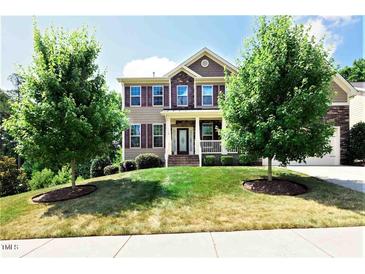 Charming two-story home with a well-manicured lawn, mature trees and a welcoming front porch at 112 Briarfield Dr, Apex, NC 27502