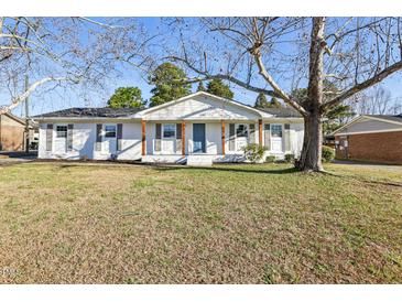 Charming one-story home with a well-manicured lawn and a welcoming front porch with stylish wooden pillars at 1246 Nc-27, Benson, NC 27504