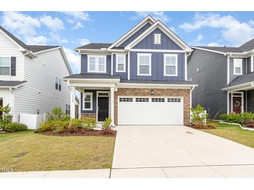 Charming two-story home showcasing navy siding, brick accents, and a spacious driveway at 1725 Winter Jasmine Ln, Wake Forest, NC 27587