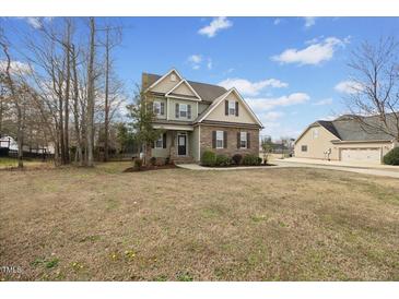 Charming two-story home with a combination of stone and siding, complemented by a well-manicured lawn and inviting curb appeal at 224 Swann Trl, Clayton, NC 27527