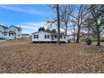 Charming single-story home featuring black shutters, white siding, and a cozy front porch at 2400 Dorety Pl, Raleigh, NC 27604