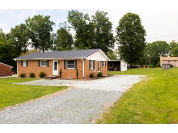 Charming brick home with gravel driveway, and well-maintained landscaping at 250 Patterson Dr, Roxboro, NC 27573