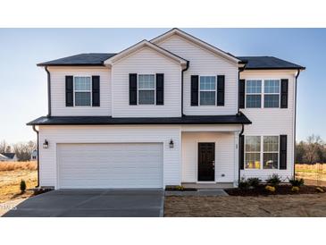 Charming two-story home featuring a white exterior, black shutters, and an attached two-car garage at 285 Johnson Ridge Way, Four Oaks, NC 27524