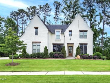 Stunning white brick home with meticulous landscaping, mature trees, and charming curb appeal at 3160 Mantle Ridge Dr, Apex, NC 27502
