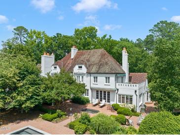Stunning aerial view of an elegant white brick home surrounded by lush greenery and a charming brick patio at 3307 Devon Rd, Durham, NC 27707