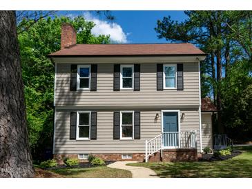 Charming two-story home with light siding, black shutters, blue door, and well-maintained landscaping at 3317 E Jameson Rd, Raleigh, NC 27604