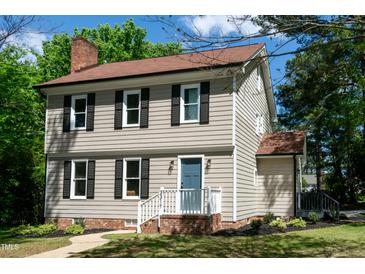 Charming two-story home with a brick foundation, fresh landscaping and a blue front door at 3317 E Jameson Rd, Raleigh, NC 27604
