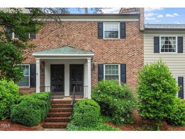Charming two-story brick townhouse with black shutters, landscaped yard, and covered front porch at 3720 Jamestown Cir, Raleigh, NC 27609
