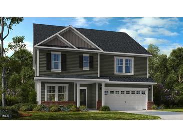 Charming two-story home featuring a two-car garage and lush landscaping, providing an inviting curb appeal at 523 Claftin St, Sanford, NC 27330