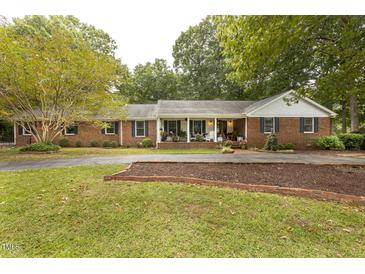 Charming brick ranch-style home with a welcoming front porch and well-manicured landscaping at 6517 Whitted Rd, Fuquay Varina, NC 27526